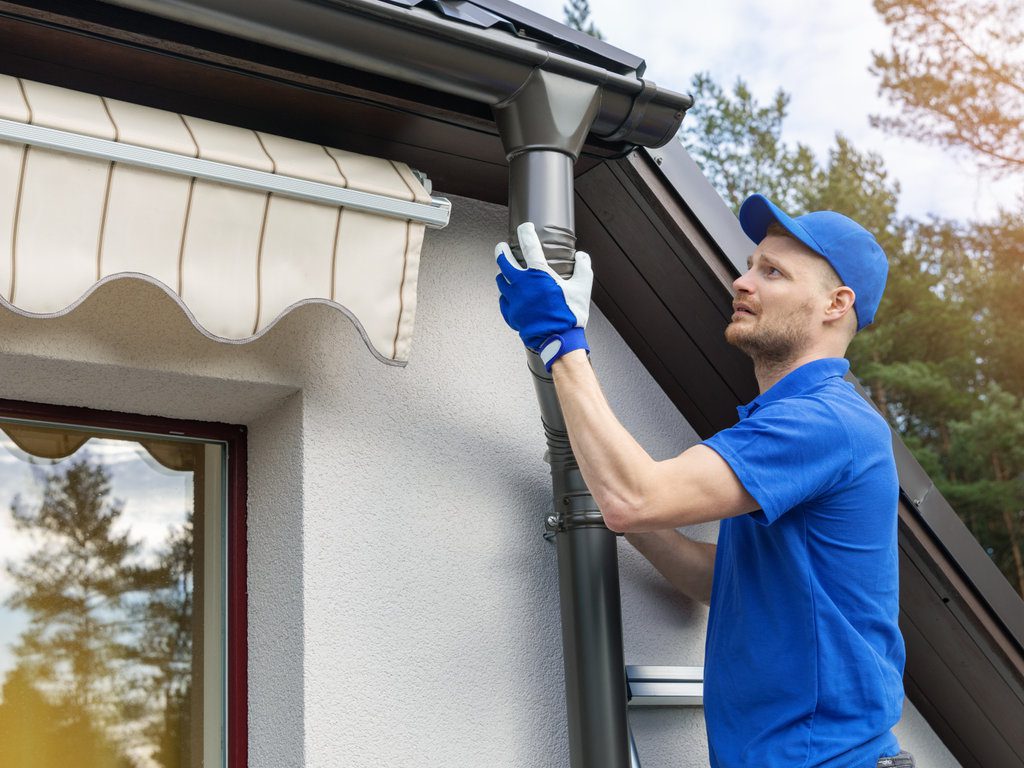 worker installing house roof rain gutter system gutter repair